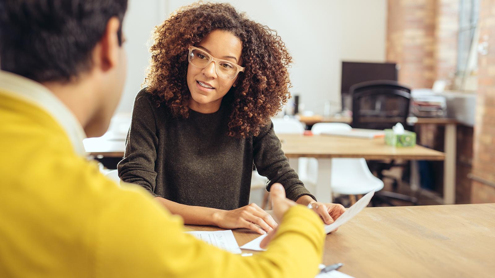 Woman talking with a colleague about a written communication.
