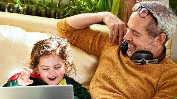 Dad and daughter holding a tablet.