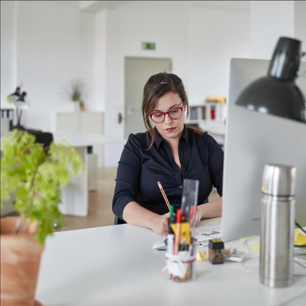 Woman sitting in office and writing.
