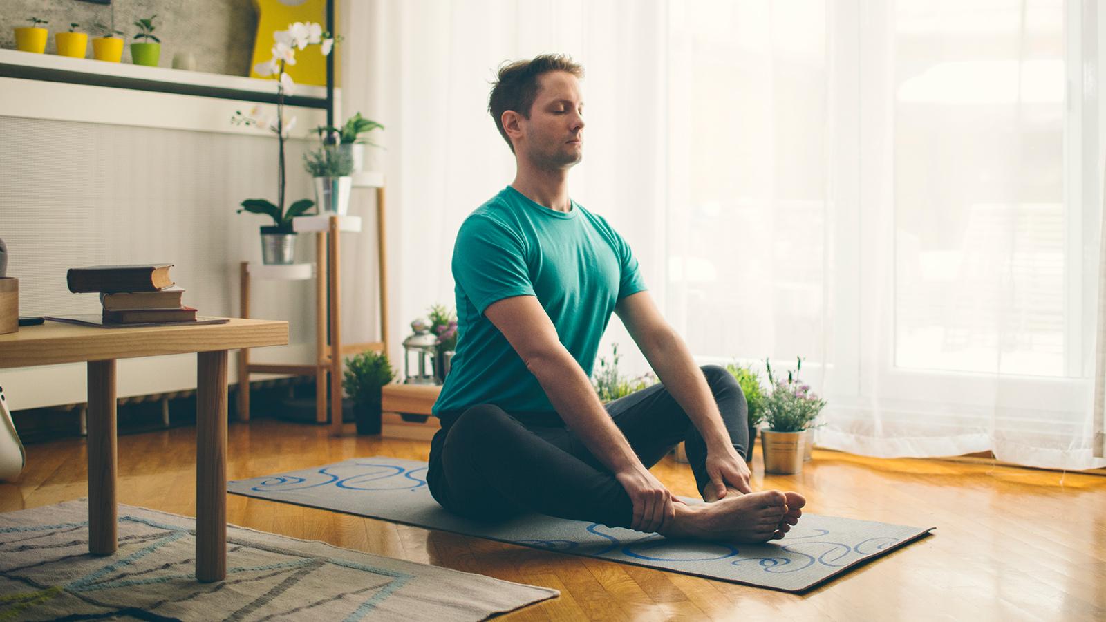 Man doing yoga in his living room.