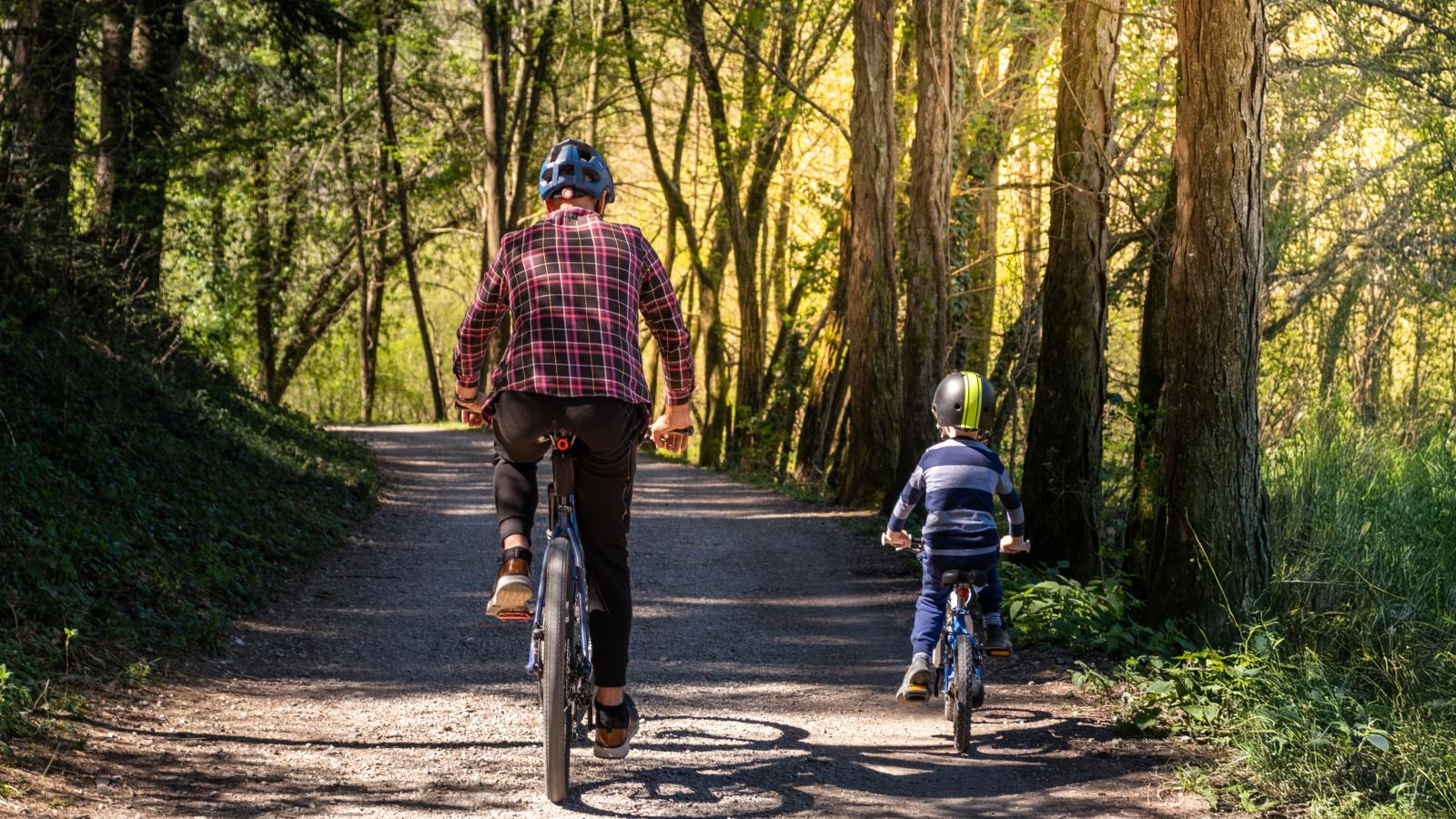 Father and son riding bikes outside. Father and son riding bikes outside.