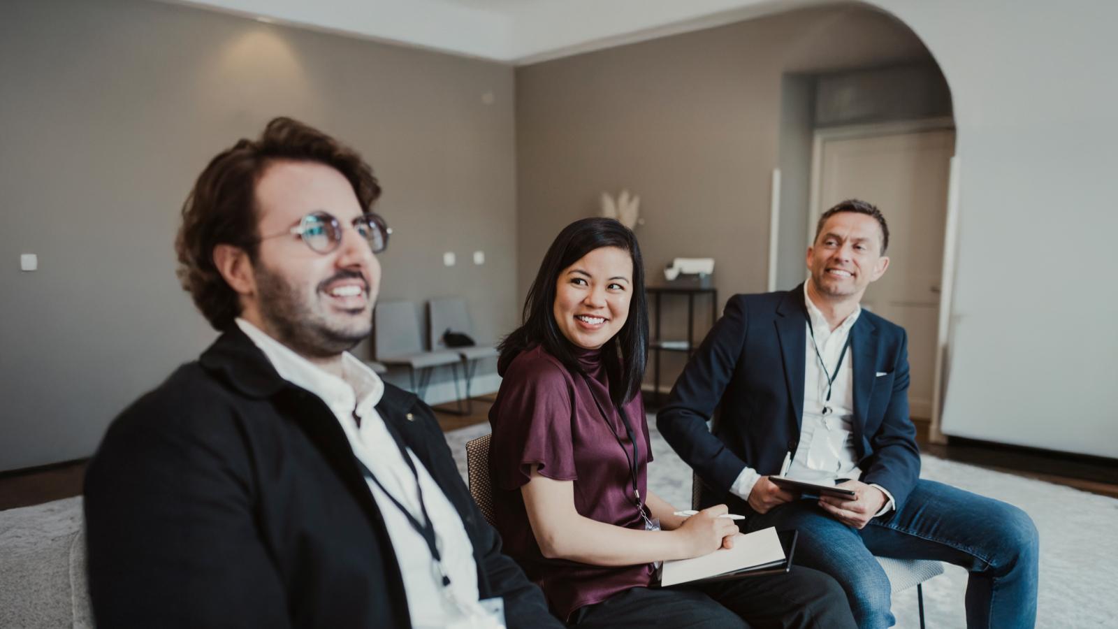 Three people sitting and taking notes