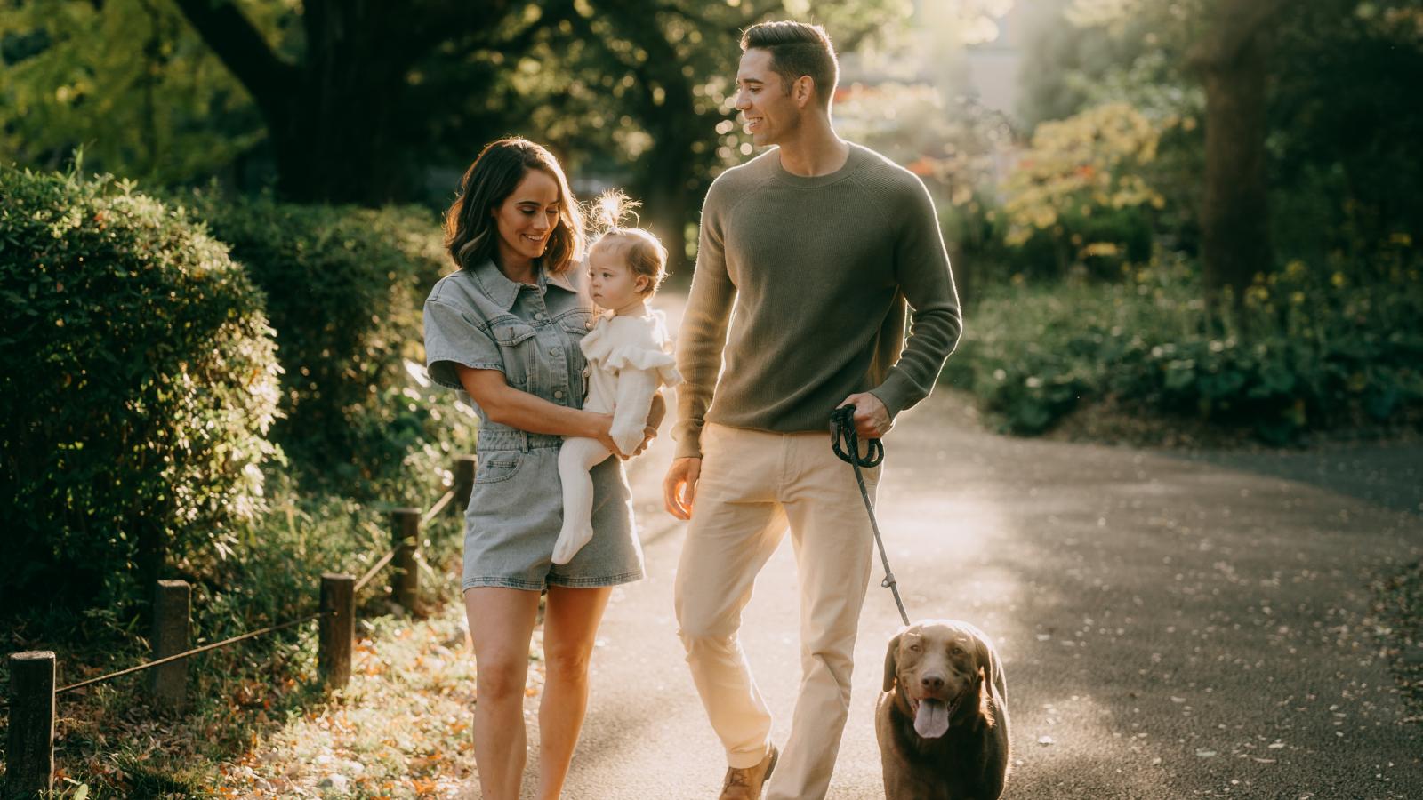 Family with dog walking in park