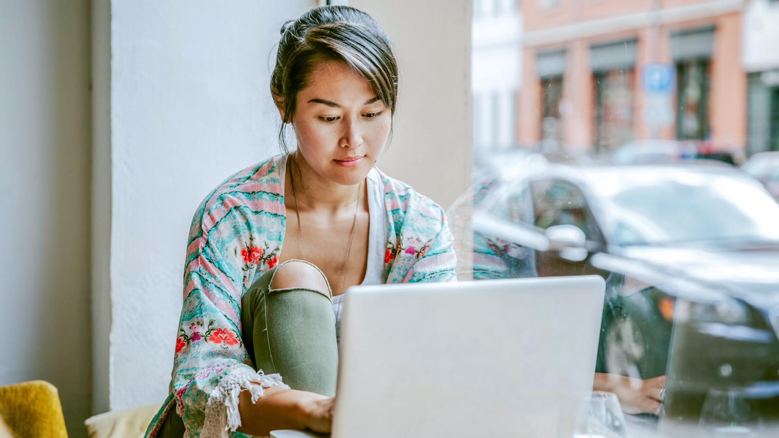 Young woman working on laptop in cafe