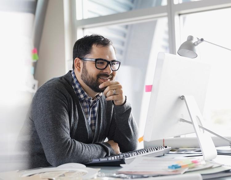 Man reading about guardian on desktop.