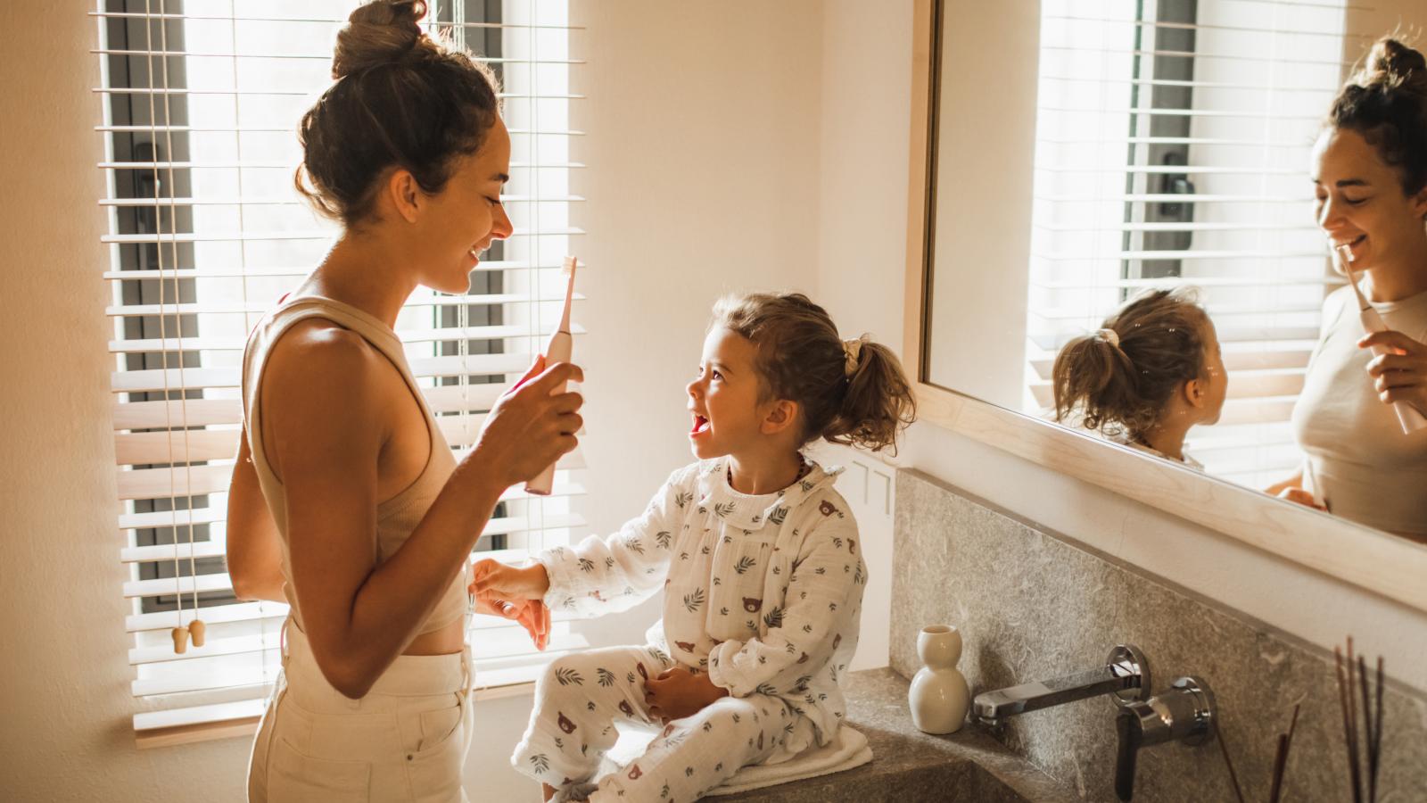Mother and daughter brushing their teeth together. Mother and daughter brushing their teeth together.
