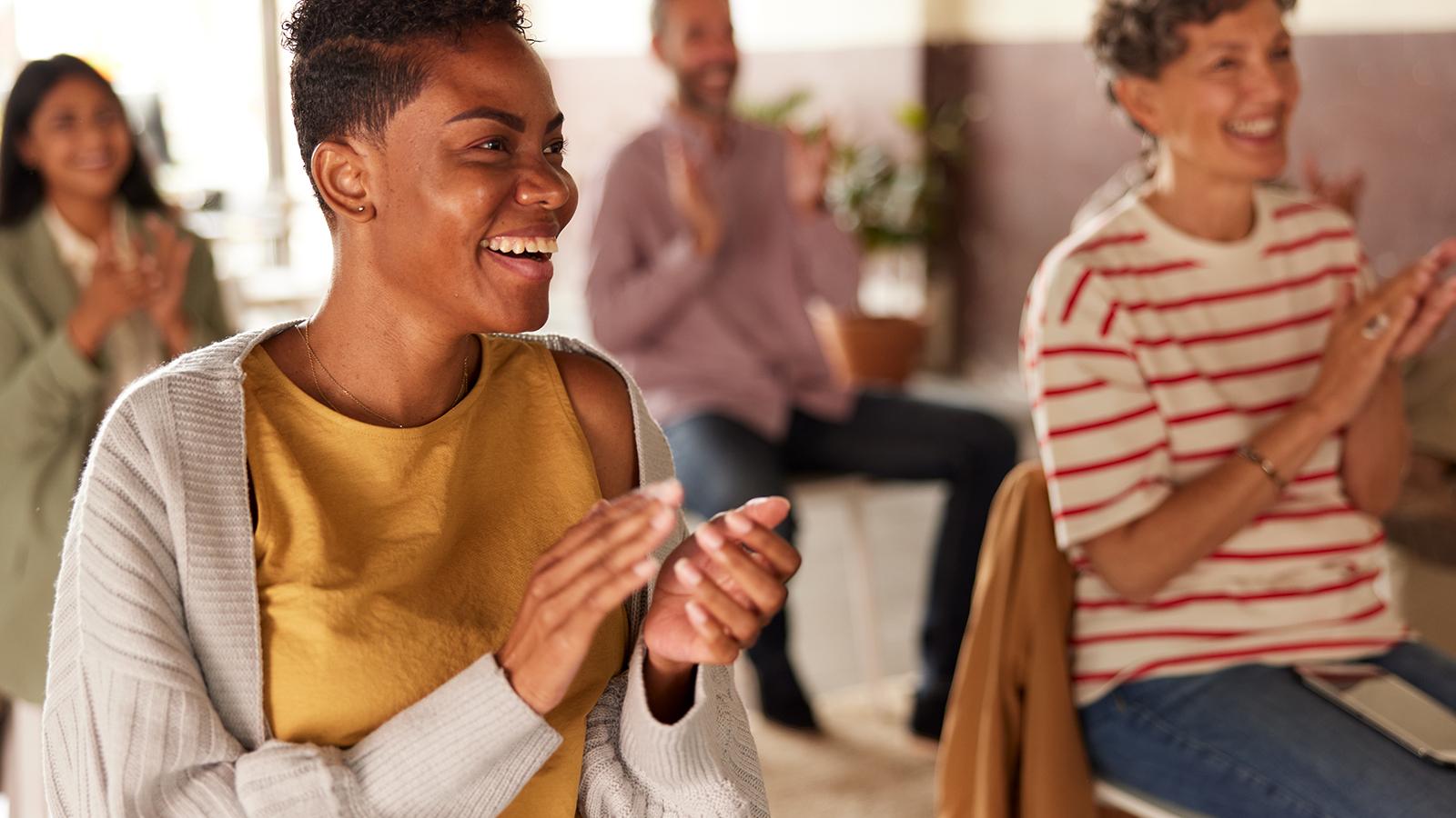 Two woman clapping in a meeting