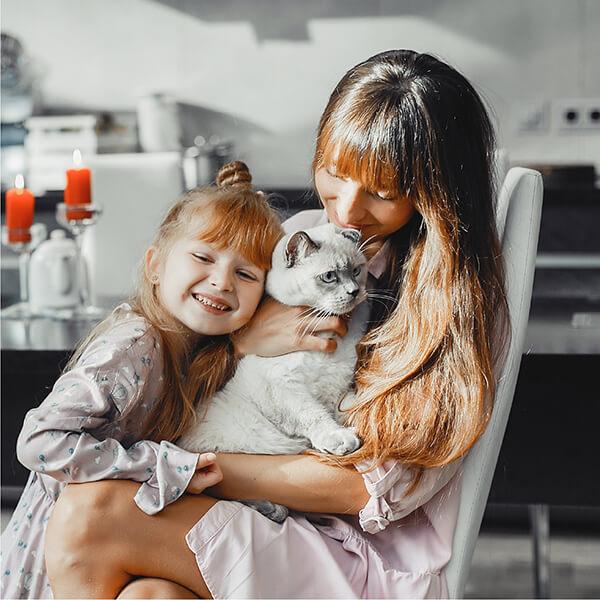 mother and daughter hugging their cat