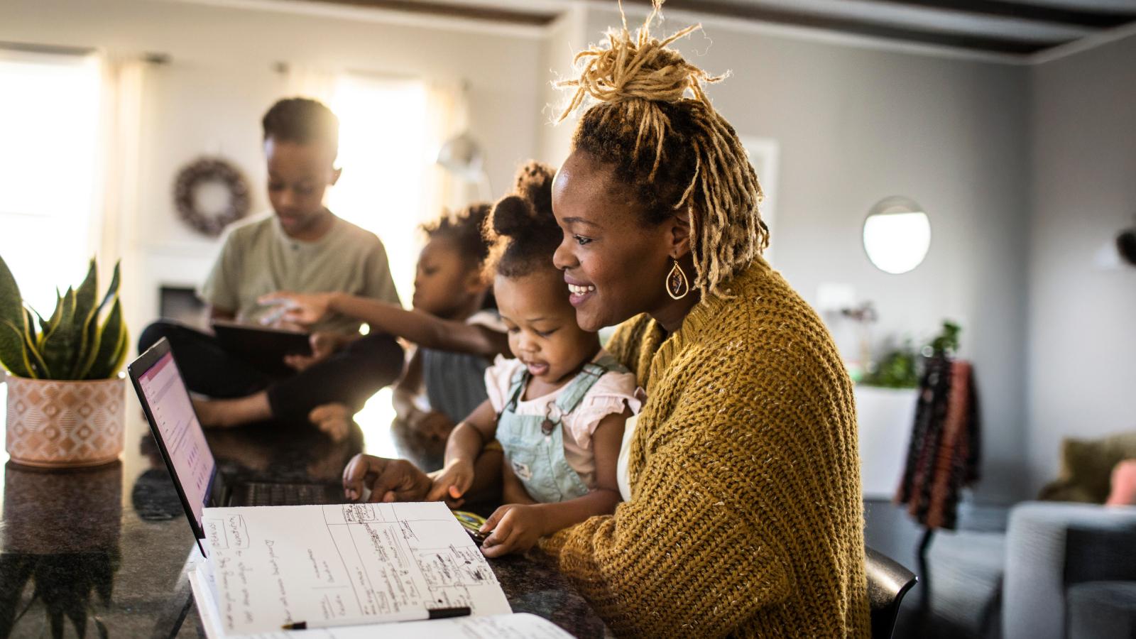 Mother working from home while holding toddler