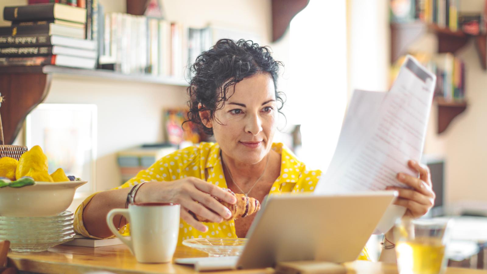 Woman reading documents over breakfast