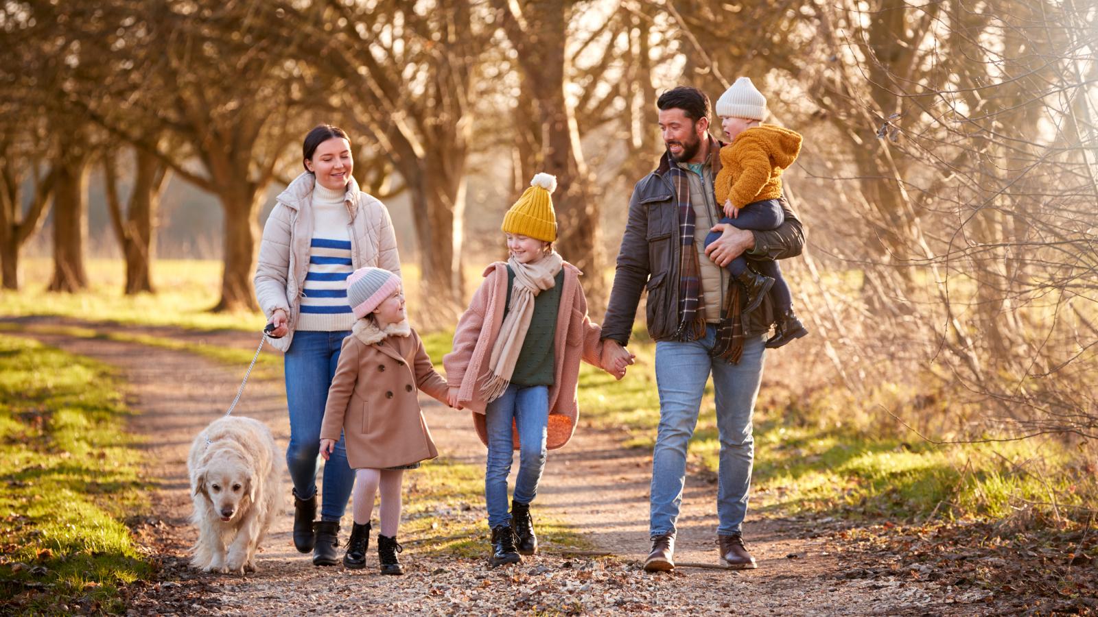 Family walking with their dog in woods