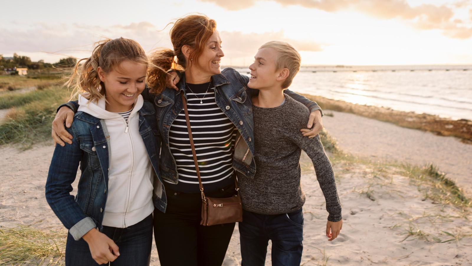 Mother walking and smiling with her two children.