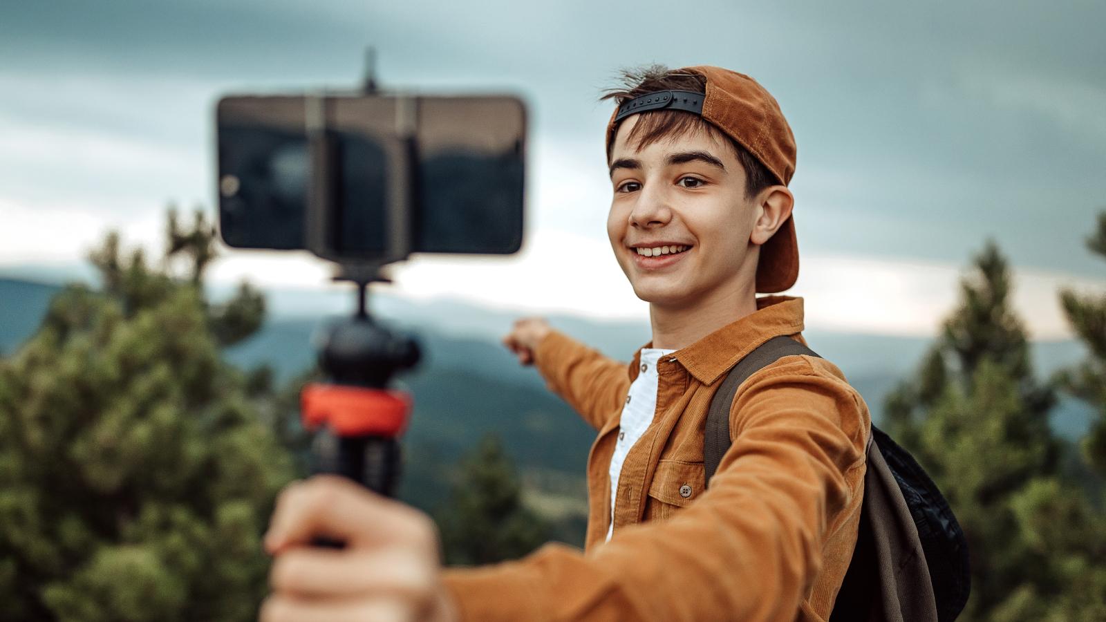 Teenage boy taking a selfie on a hike.