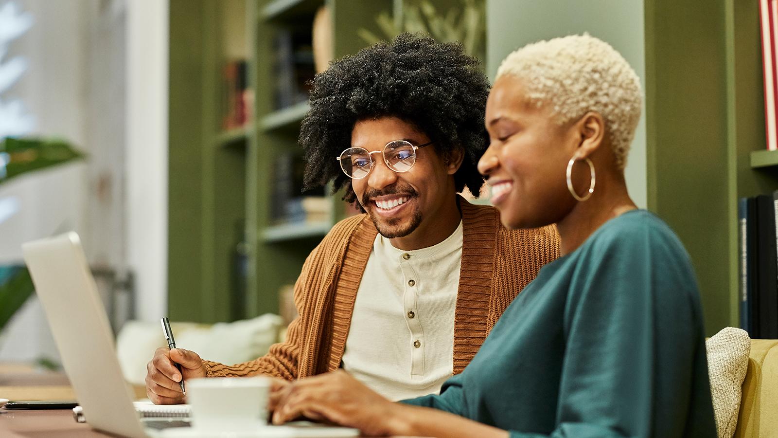 Two employees looking at a laptop together