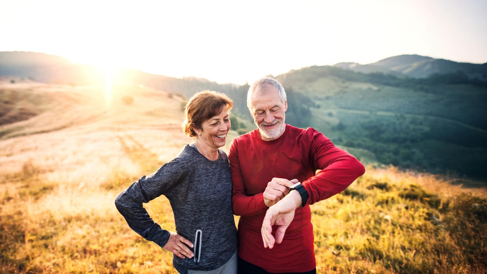 Senior couple runners resting outdoors in nature