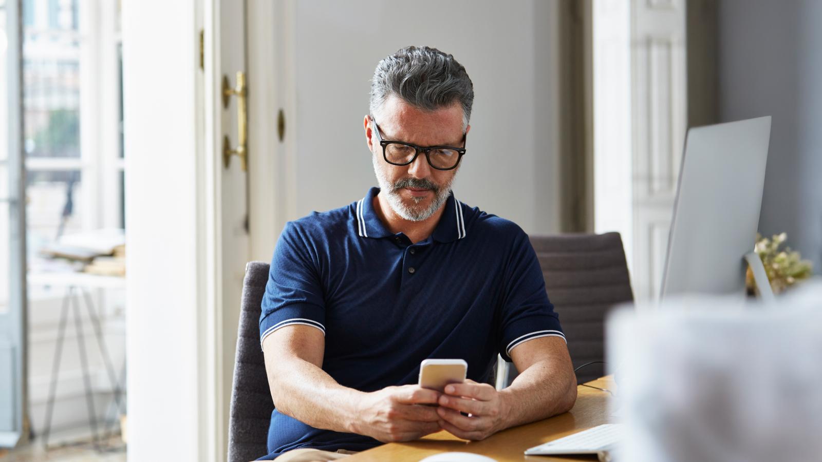 Businessman using mobile phone at desk