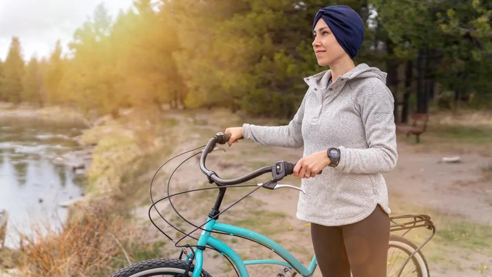 A woman with cancer taking a break from a bike ride to take in the scenery.