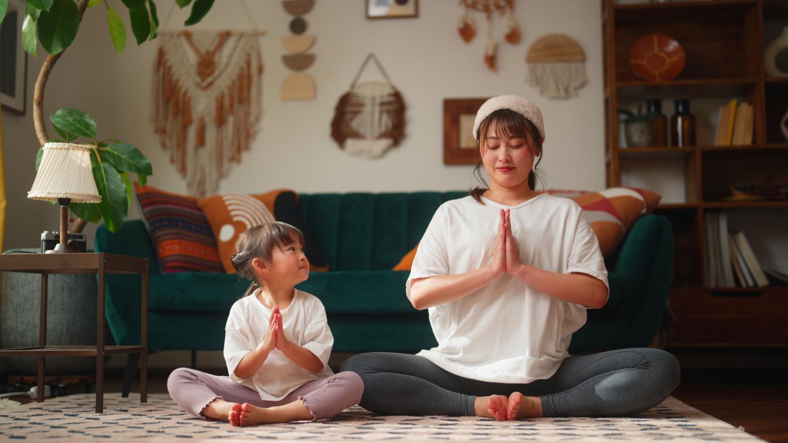 Mother and daughter practicing yoga at home