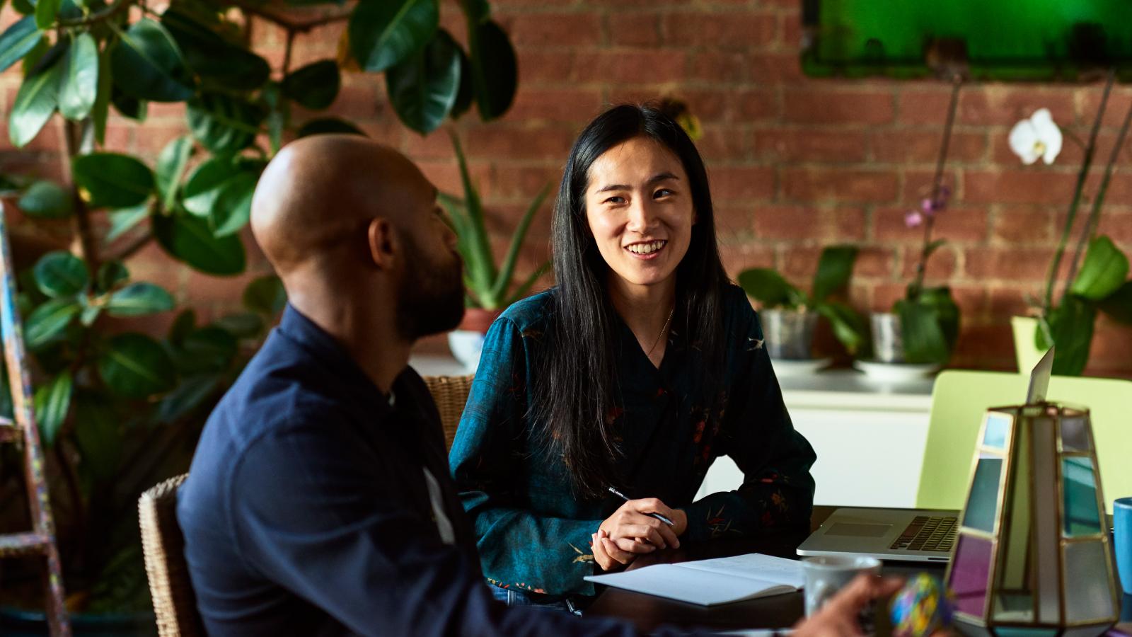 Man and woman having a conversation at her desk