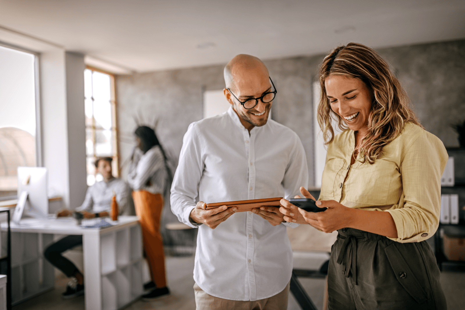man and woman looking at mobile devices