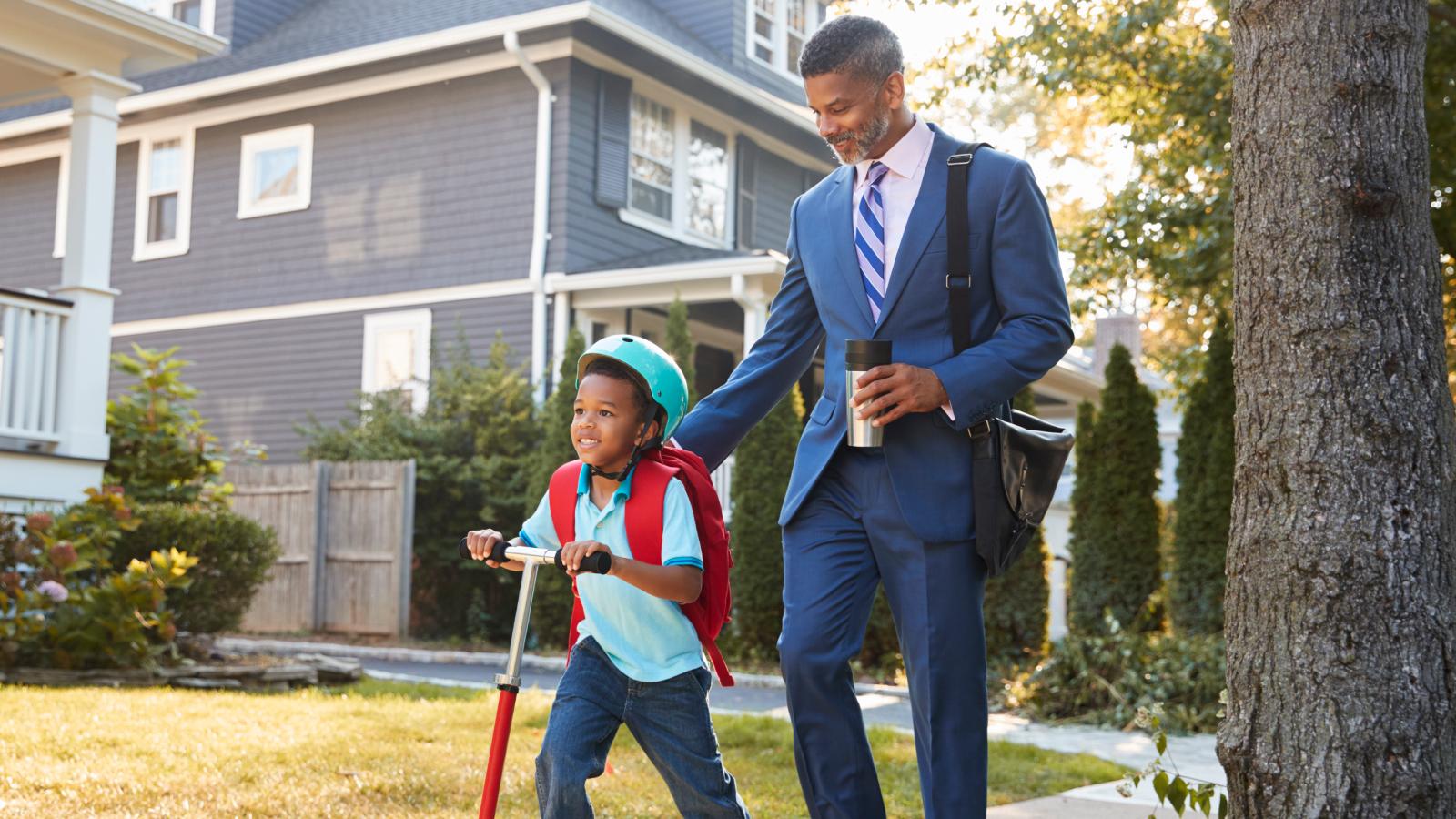 Father looking at son and smiling while walking on road