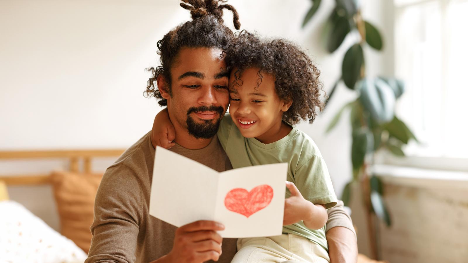 Son gifting handmade postcard to father