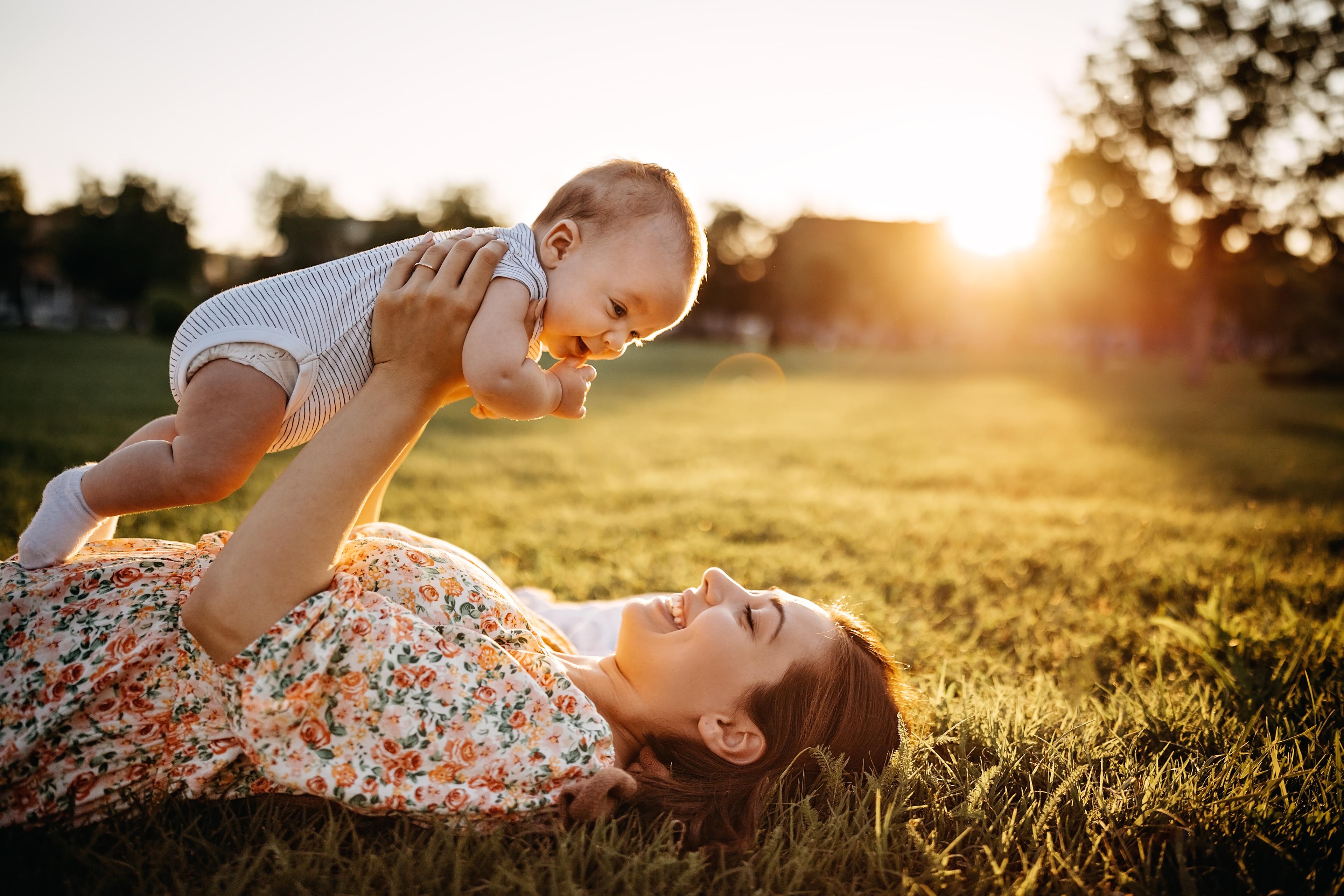 Mother playing with her baby outside.