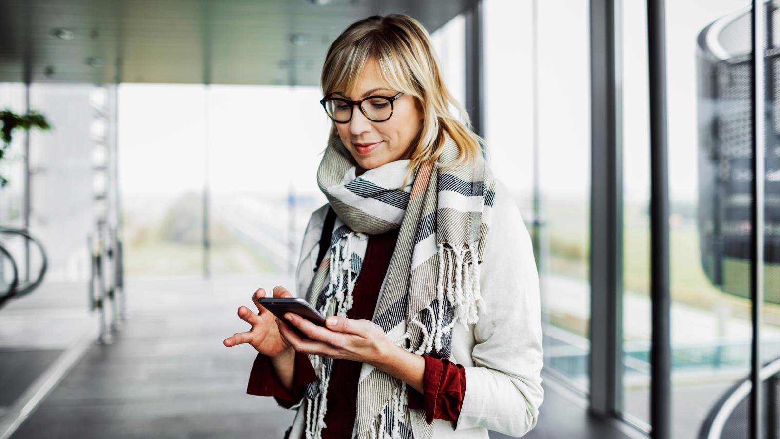 Businesswoman with smart phone standing at the airport