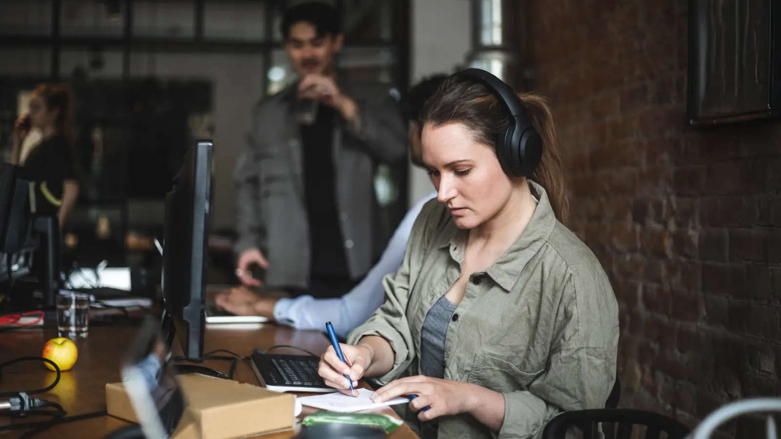 Businesswoman writing in notebook while working