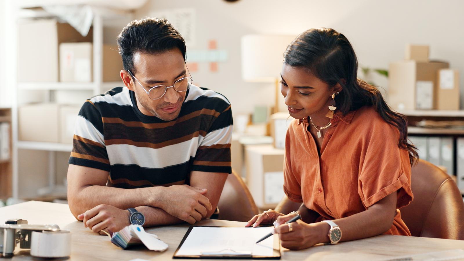 Coworkers going over a project in the office. Coworkers going over a project in the office.