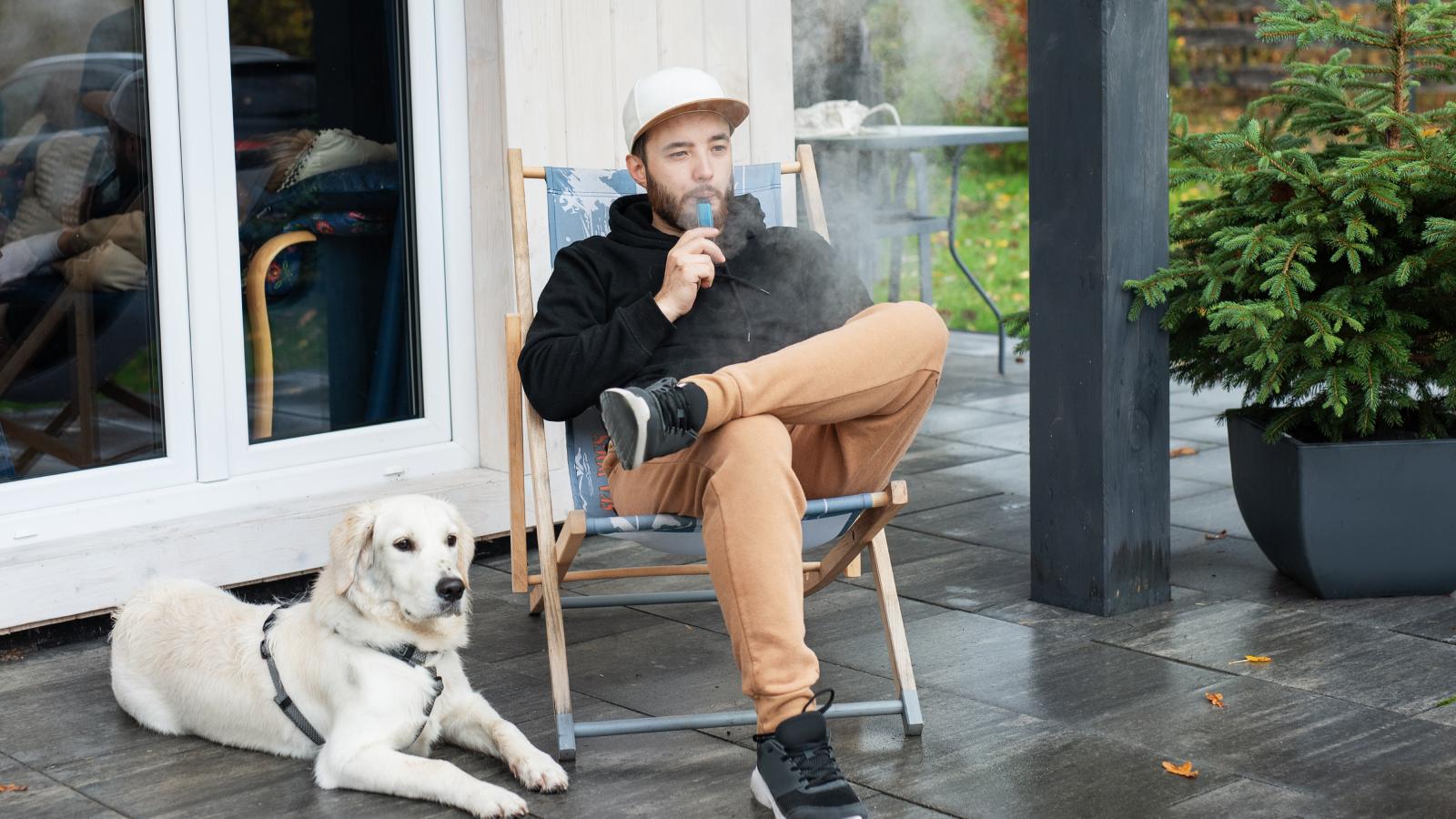 Young man sitting with dog on terrace
