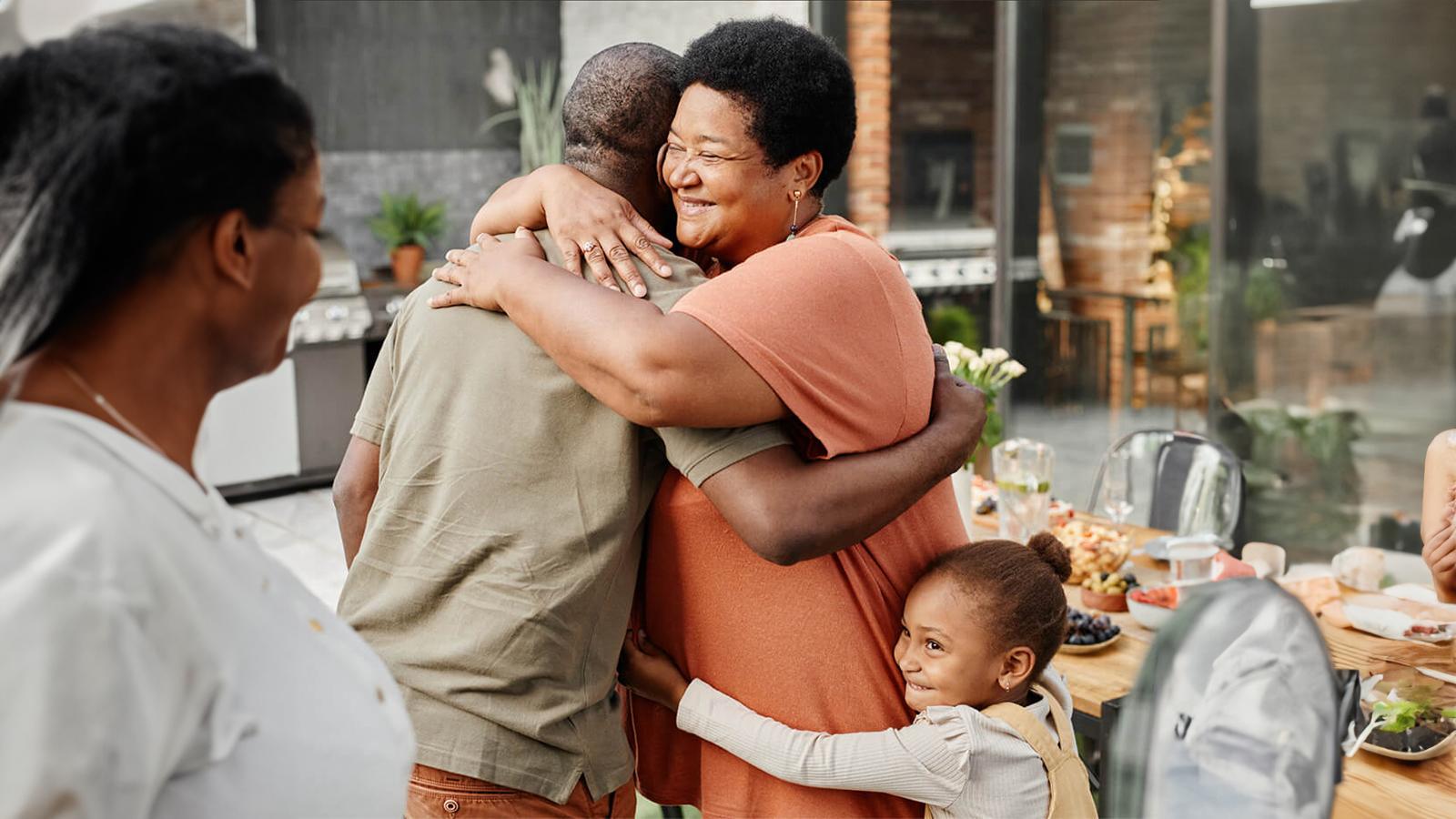 Parents hugging with their daughter hugging the mom from behind