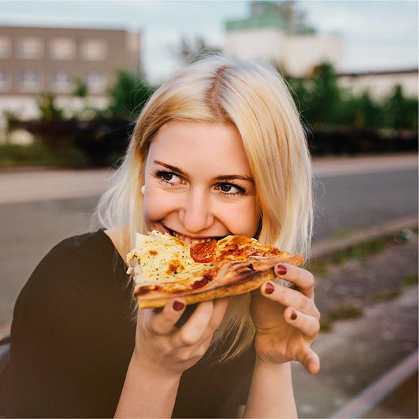 Woman eating pizza outside Woman eating pizza outside