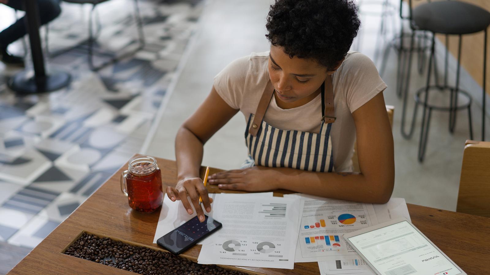 Female employee using her phone to calculate her finances