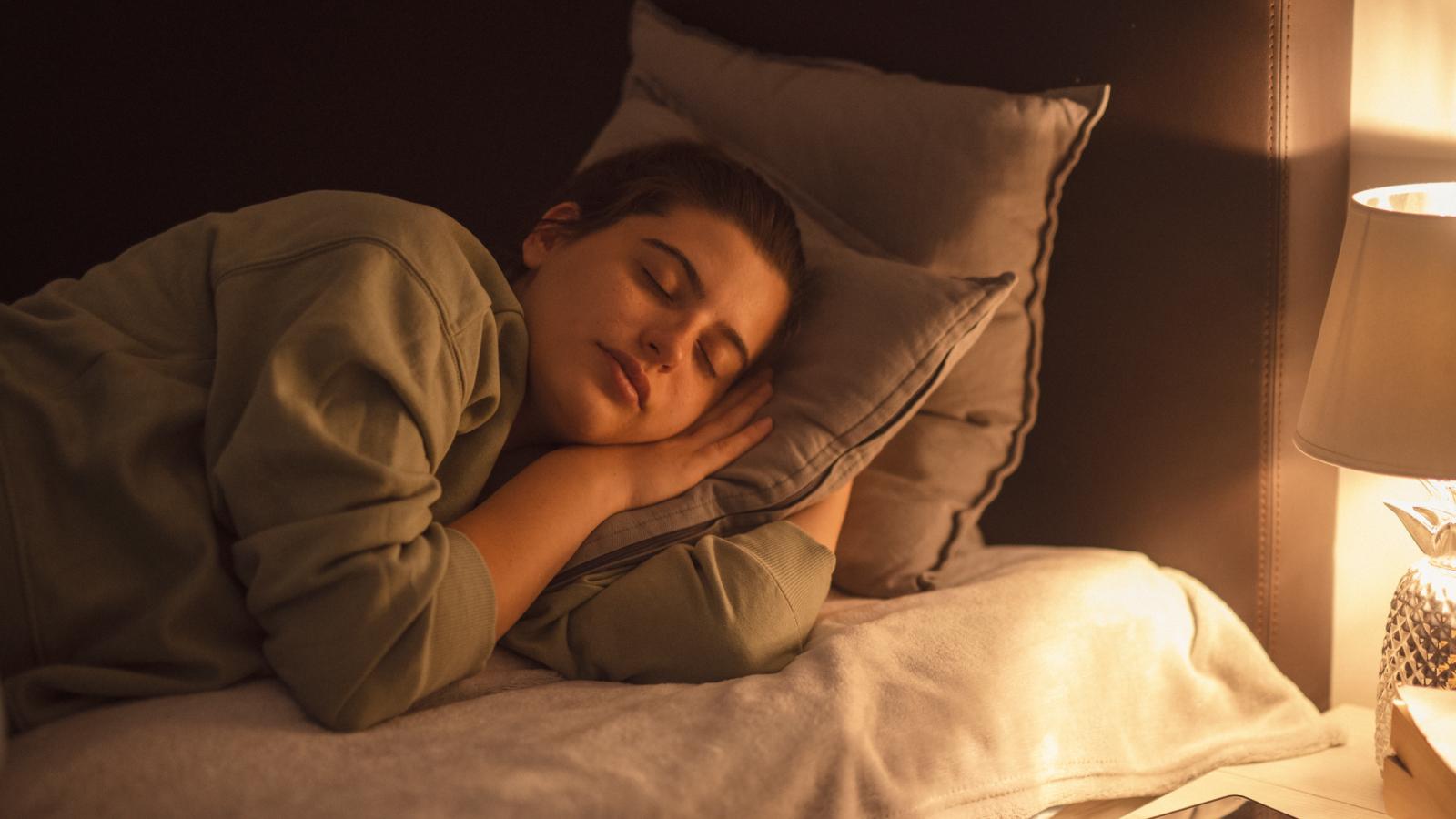 Lamp illuminating sleeping woman at night