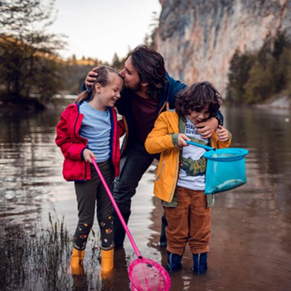 Father and kids fishing in a lake.