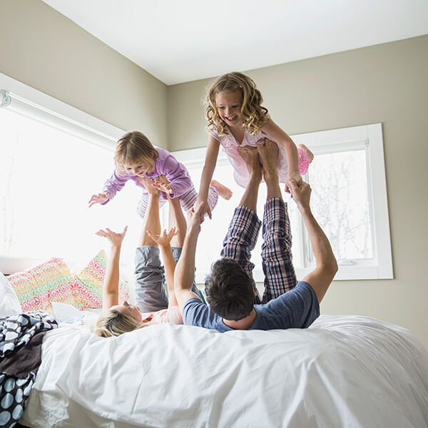 parents-lifting-girls-on-bed