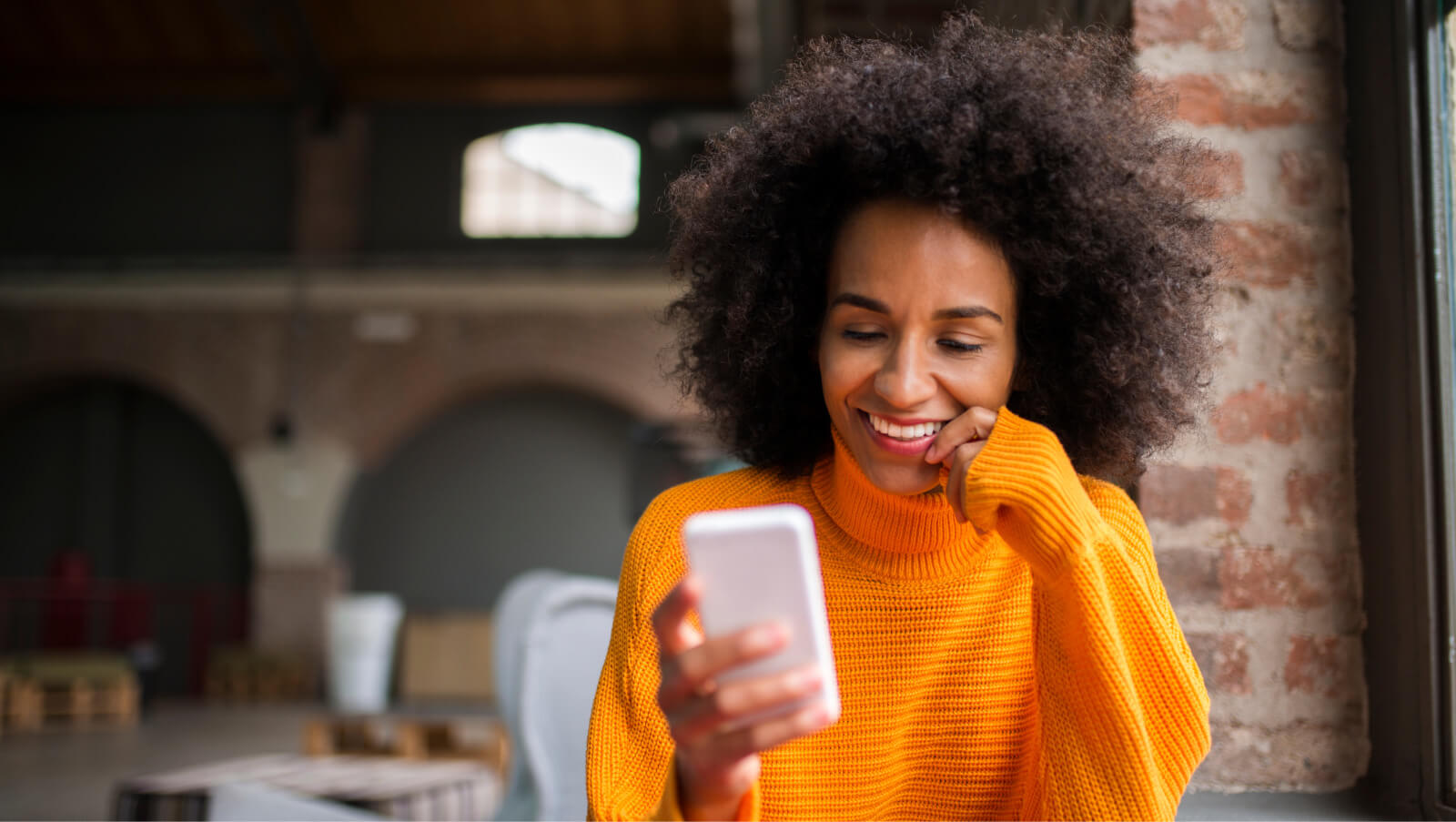 Woman smiling and looking at her phone. 