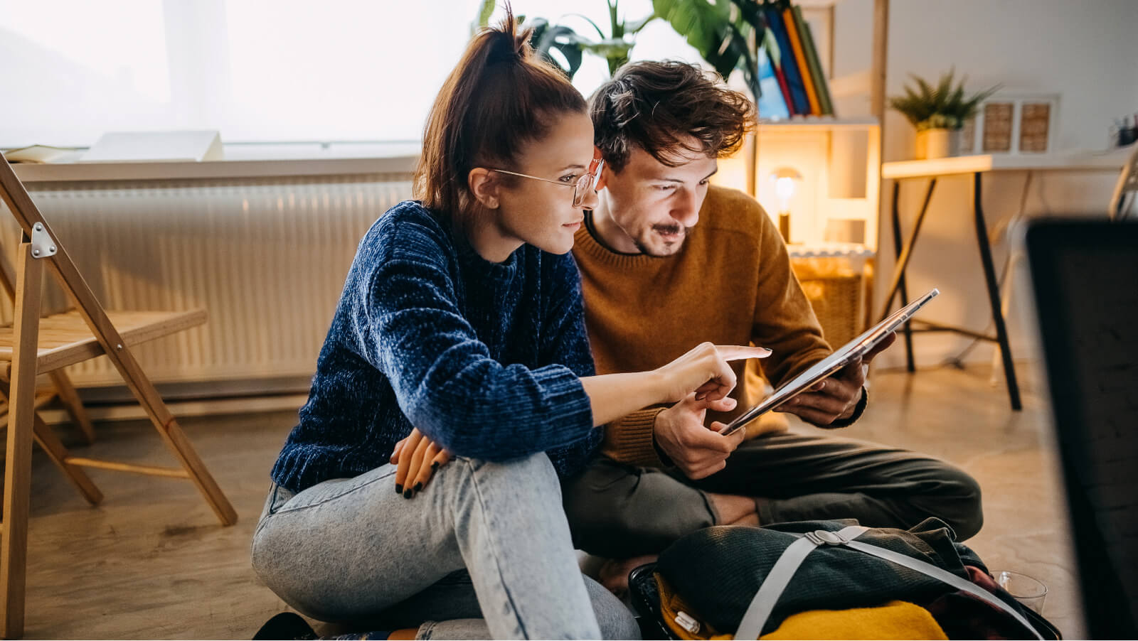 Couple casually comparing options together at home on tablet device