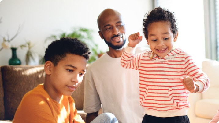 Father at home smiling and interacting with his two young sons.