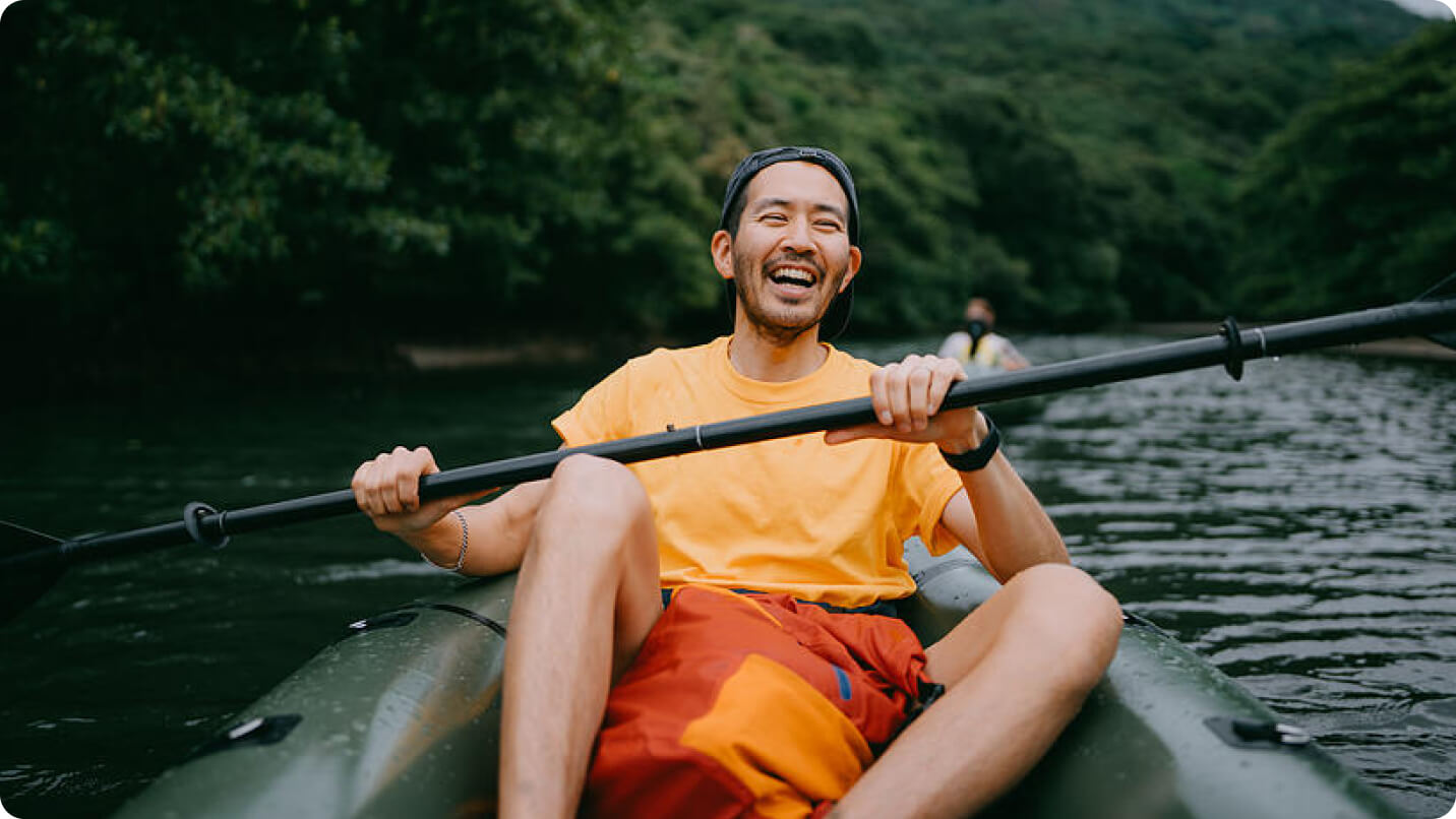Man sitting in a kayak and paddling.