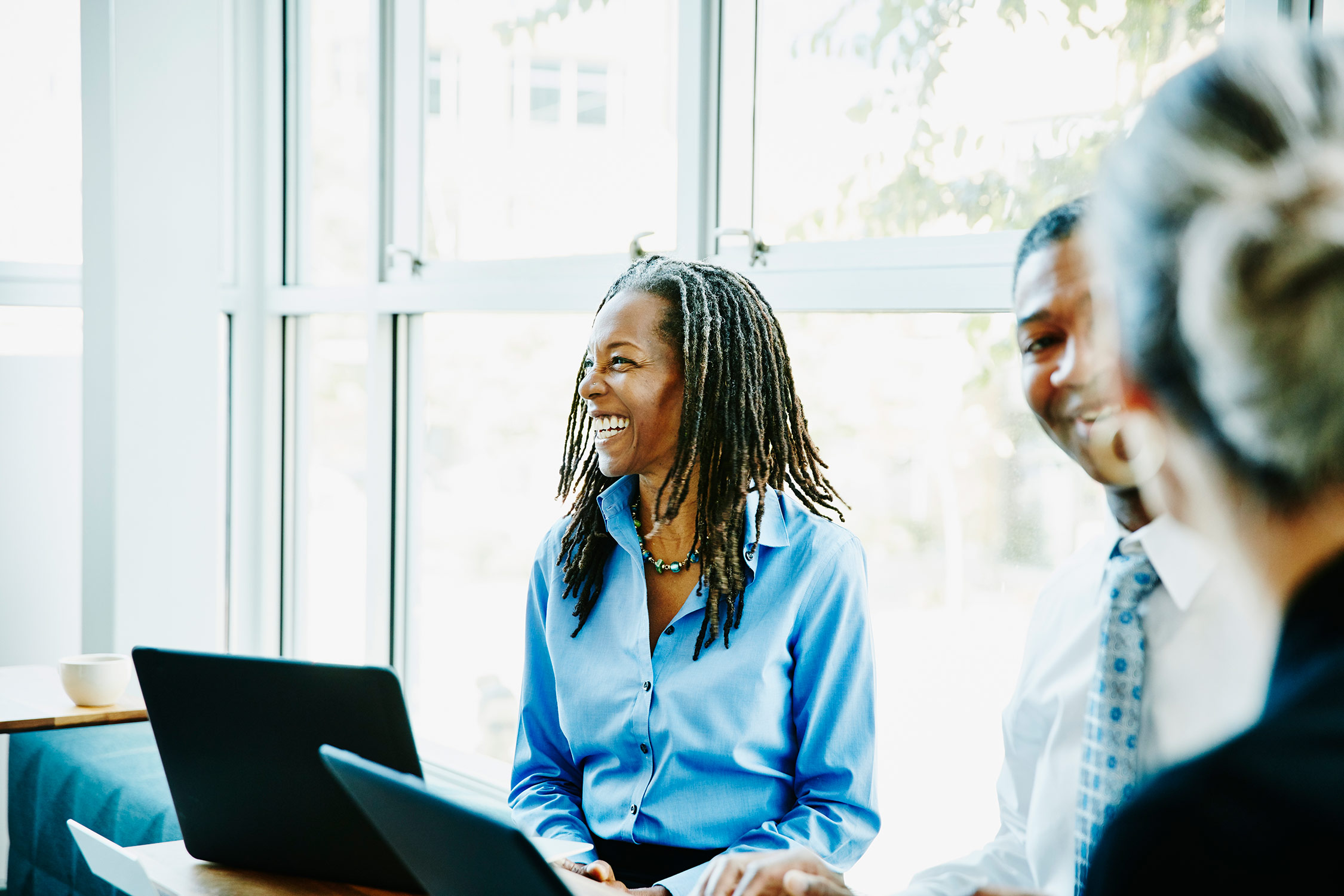 African American woman smiling and sitting at a meeting