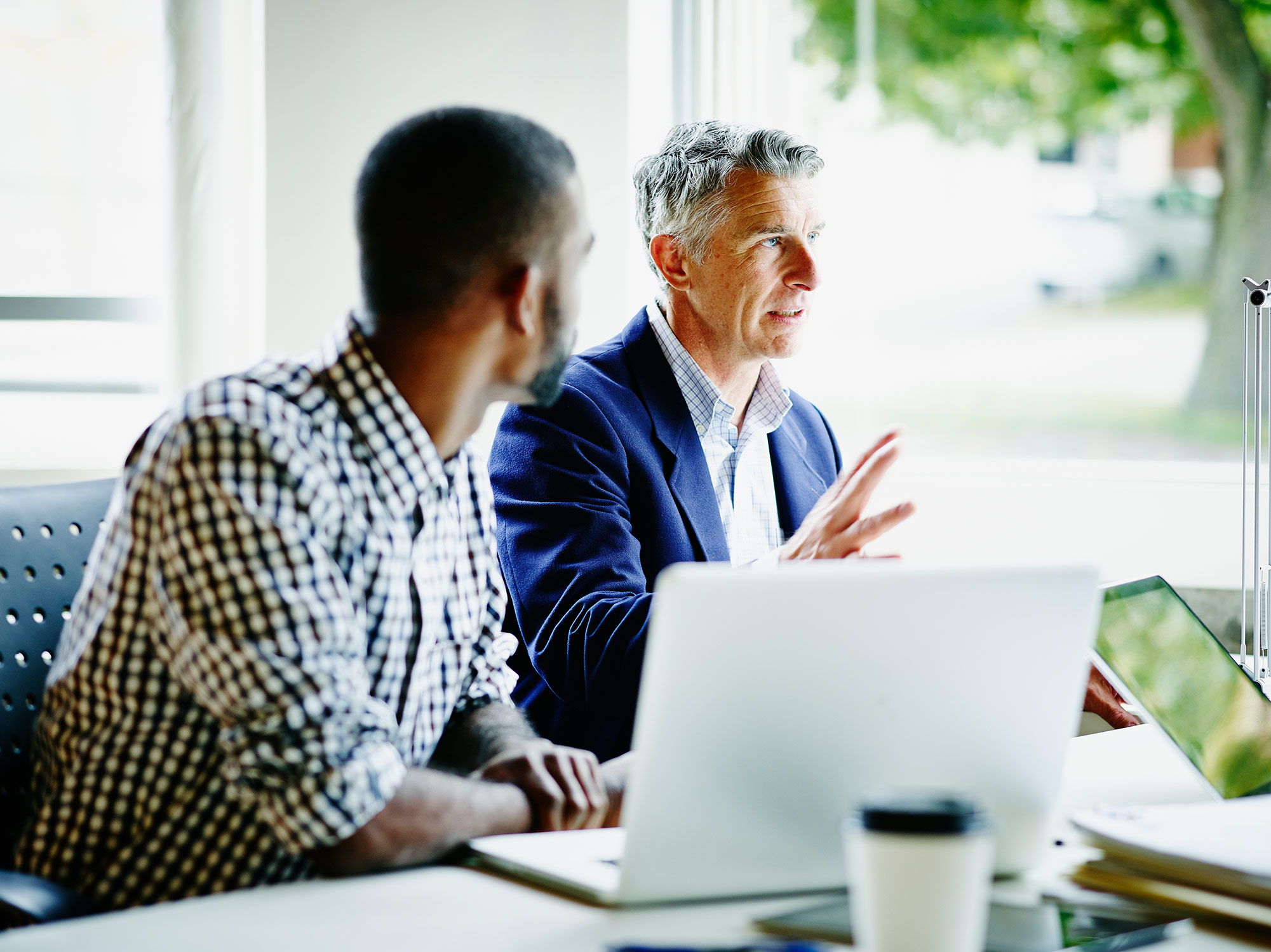 2 male financial representatives at a meeting